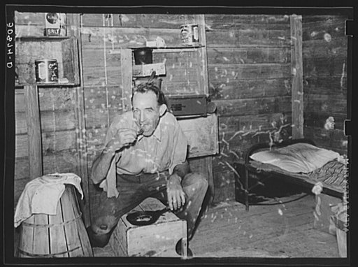 Migrant agricultural worker from Tennessee, formerly a railroad man, eating dinner in his shack, an old tool house. Homestead, Florida