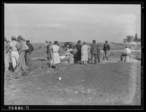 Untitled photo, possibly related to: Negro agricultural laborers watching one of their houses burn to the ground. All they have left is piled on the ground