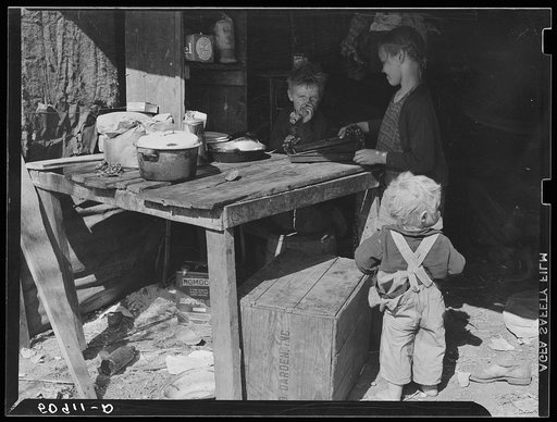 Untitled photo, possibly related to: Children of migrant packinghouse workers, living in a "lean-to" made of pieces of rusty galvanized tin and burlap. They are left alone all day and often until three a.m. Both parents work when possible. Belle Glade, Florida