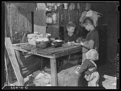 Children of migrant packinghouse workers, living in a "lean-to" made of pieces of rusty galvanized tin and burlap. They are left alone all day and often until three a.m. Both parents work when possible. Belle Glade, Florida