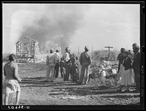 Untitled photo, possibly related to: Negro agricultural laborers watching one of their houses burn to the ground. All they have left is piled on the ground. Lake Harbor, Florida