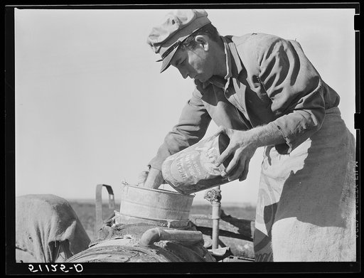 Migrant day laborer from Carolina mixing spray to kill white flies and nourish bean plants through leaves. Near Belle Glade, Florida.