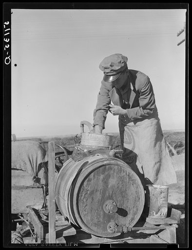 Migrant day laborer from Carolina mixing spray to kill white flies and nourish bean plants through leaves. Near Belle Glade, Florida