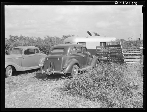 Migrant workers parked as close to the packinghouse as possible, so that they will be on hand when the trucks bring in the produce. Belle Glade, Florida