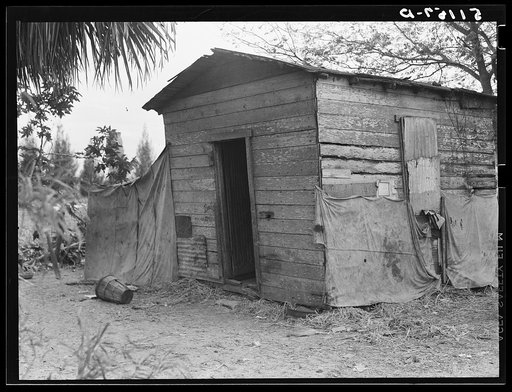 Migrant vegetable pickers and packinghouse workers living quarters. This shack rents for eight dollars a month: no water, light, or sanitary facilities.  Eleven people sleep in it. Near Canal Point, Florida