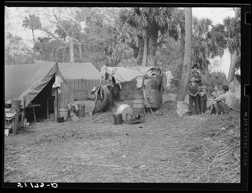 Migrant packinghouse workers living quarters. Just enough land to set up camp rents for five dollars per month; they have to clear it themselves. No water, lights or sanitary facilities. Near Canal Point, Florida