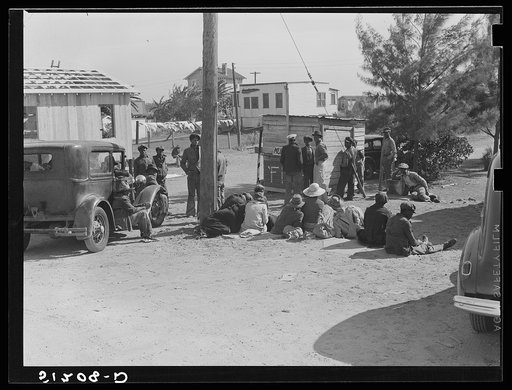 Untitled photo, possibly related to: Migrant laborers waiting for truck to haul them to fields to pick beans. Near Lake Harbor, Florida