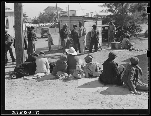 Migrant laborers waiting for truck to haul them to fields to pick beans. Near Lake Harbor, Florida