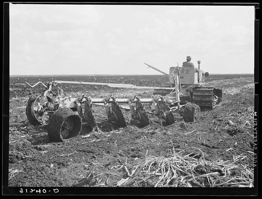 Tractor-driven disc gang plough used on large tracts of land before planting sugarcane. USSC (United States Sugar Corporation). Clewiston, Florida
