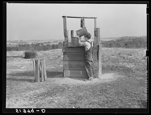 Lewis boy getting water from old well, typical of most in area where wells are very often polluted. Coffee County, Alabama