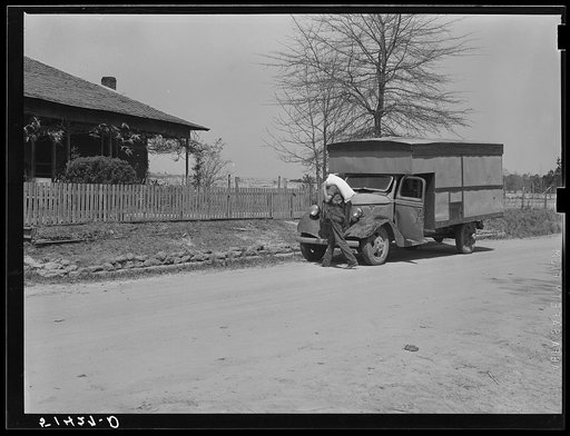 A "rolling store" salesman carrying sack of flour into rural home. Coffee County, Alabama