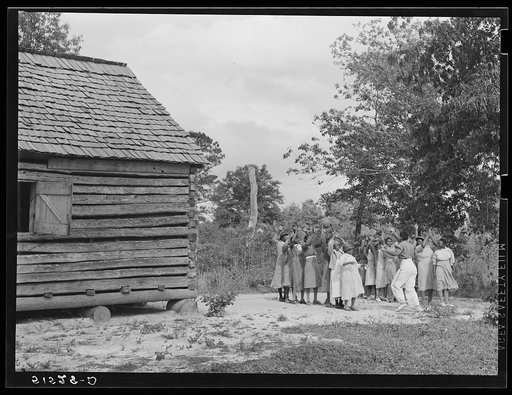 Outdoor games and recreation led by Florence Wright (in white slacks), recreation supervisor for adult group. They meet in church at left for classwork. Reading, writing, arithmetic and general discussion and educational activities. Gee's Bend, Alabama