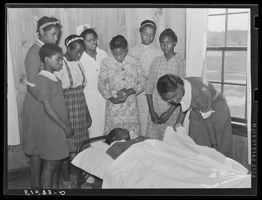 Nurse Shamburg directs group of girls in making sick bed in clinic. Gee's Bend, Alabama