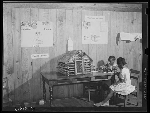 Juanita Eygran and Jeredine Burman cutting out health pictures to paste on second and third grades health house. Flint River Farms, Georgia