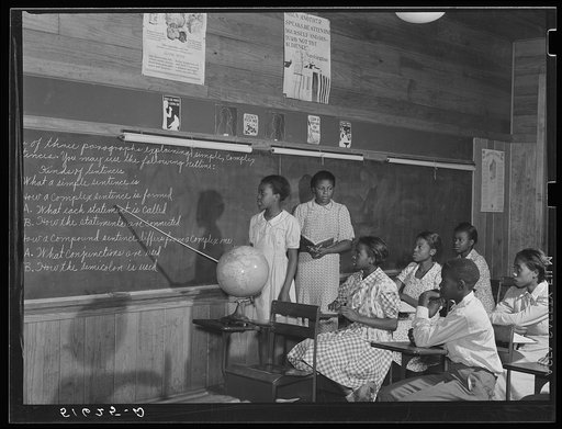 English lesson in sixth and seventh grade school room. Selma Sutton at board with teacher, Miss Jessie West Greene. Flint River Farms, Georgia