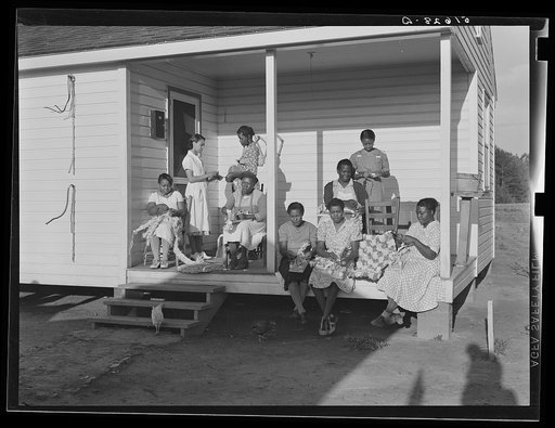 Untitled photo, possibly related to: Home economics and home management class for adults, under supervision of Miss Evelyn M. Driver (standing in white uniform). Everything they make including the small handmade looms, utilizes materials of local origin as cornshucks, cane, flour and meal and feed s