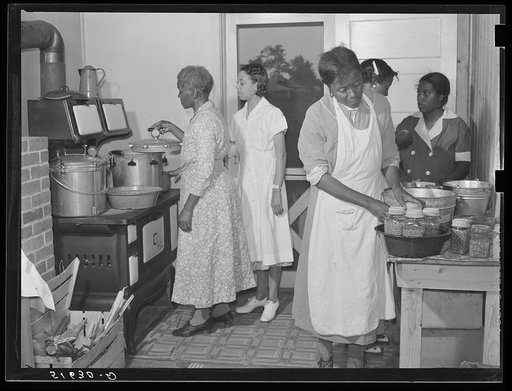 Home management and economics class canning peas with pressure cookers under supervision of Miss Evelyn M. Driver (in white uniform). Others are Ada Turner, Hattie Bowman, Louise Thomas and Mrs. Missouri Thomas, whose kitchen they are using. Flint River Farms, Georgia
