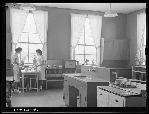 Dorothy Smith and Elizabeth Atkinson setting table in home economics room in school building. Ashwood Plantations, South Carolina