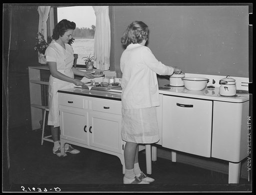 Untitled photo, possibly related to: Margaret Segars at sink with dinner tray showing well-balanced meal at right. In background are Dorothy Smith and Elizabeth Atkinson cooking on electric stove in home economics class room in school building. Ashwood Plantations, South Carolina