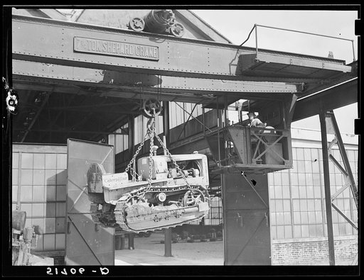 Shepard crane lifting tractor brought to FSA (Farm Security Administration) warehouse depot for repairs. Atlanta, Georgia