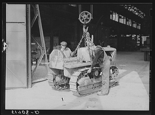 Tractor is brought into repair shop in FSA (Farm Security Administration) warehouse depot by Shepard crane. Atlanta, Georgia