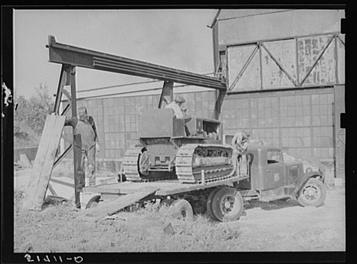 Repaired tractor being loaded from bank to truck ready to leave FSA (Farm Security Administration) warehouse depot in Atlanta, Georgia