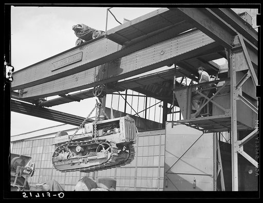 Untitled photo, possibly related to: Tractor, transported by truck to FSA (Farm Security Administration) warehouse depot for repairs, being hoisted by Shepard crane to shop inside. Atlanta, Georgia