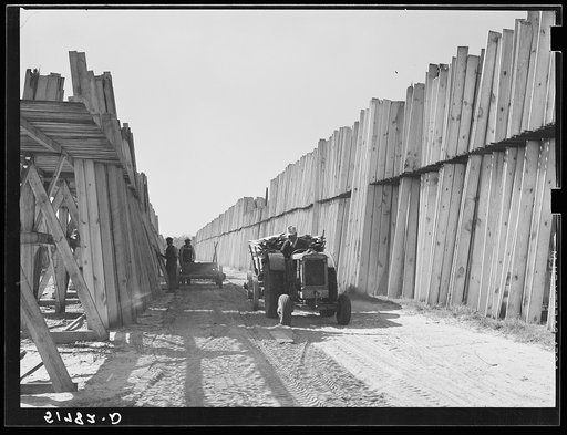 Stacks of lumber with tractor in planing mill. Cairo, Georgia