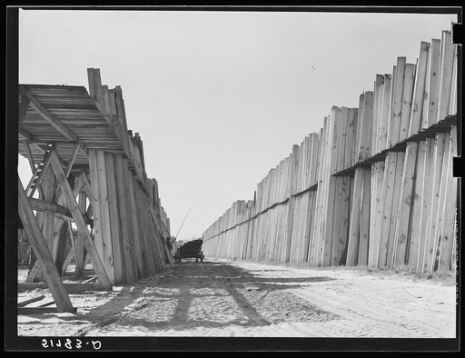 Untitled photo, possibly related to: Stacks of lumber with tractor in planing mill. Cairo, Georgia