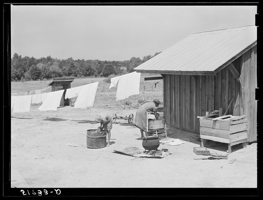 Untitled photo, possibly related to: Lonny Smith's wife and daughter doing laundry by new smoke and washhouse in their yard. Flint River Farms