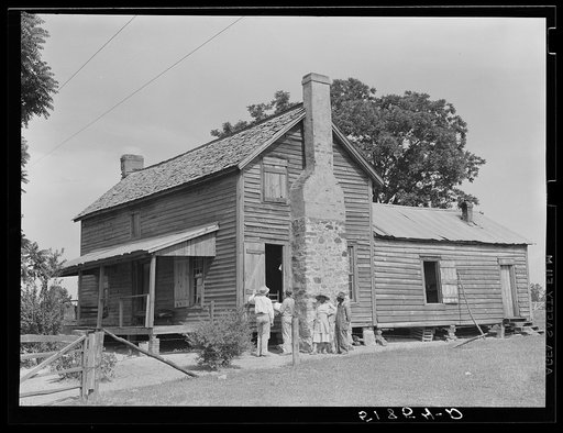 FSA (Farm Security Administration) supervisor measuring windows of Henry Mitchell's home for screens. Greene County, Georgia