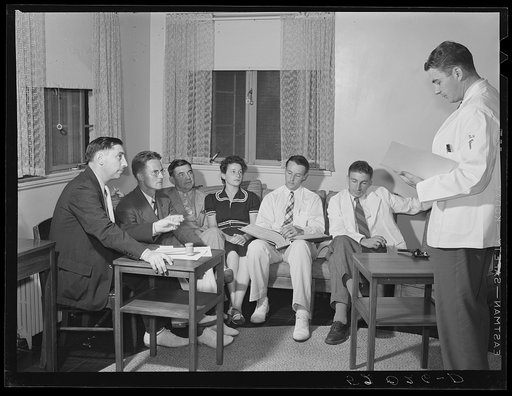 Doctor reading paper to members of board of directors of Greenbelt, Maryland medical association
