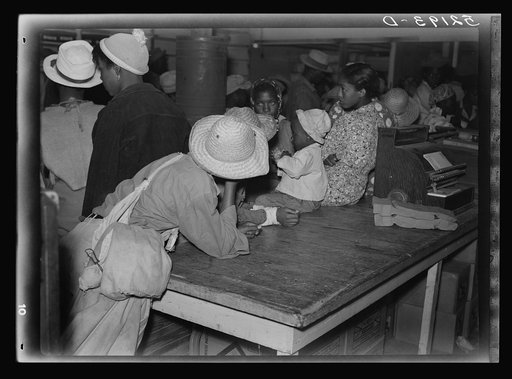 Negro day laborers brought in truck from nearby towns, waiting to be paid off for cotton picking and buy supplies inside plantation store on Friday night. Marcella Plantation. Mississippi Delta. Mississippi