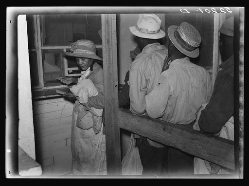 Negro day laborers brought in by truck from nearby towns, waiting to be paid off and buy supplies in plantation store on Friday night. Marcella Plantation, Mississippi Delta, Mississippi