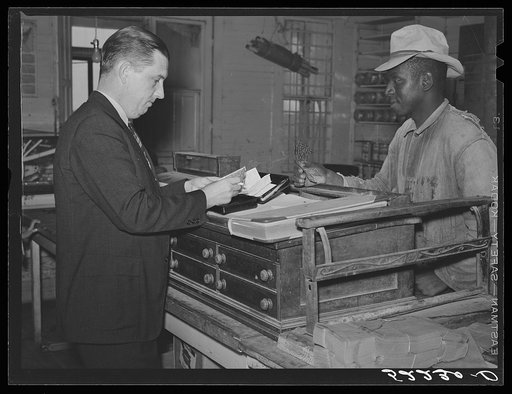 The business manager on Marcella Plantation paying off one of the tenants. Saturday, Mileston, Mississippi Delta, Mississippi