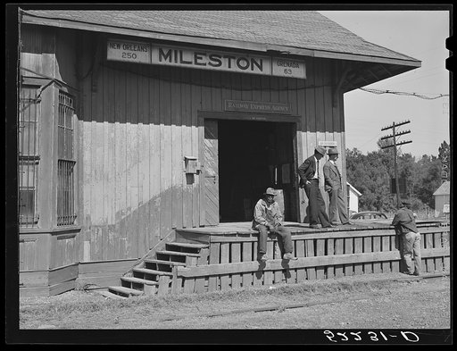 The railway station at Mileston Plantation is the social gathering place. On the platform are the station agent and the plantation owner, Mr. Jones. Mileston, Mississippi Delta, Mississippi