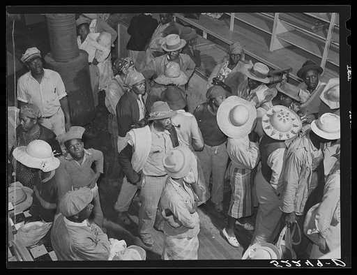 Negro day laborers brought in by truck from nearby towns waiting to be paid off for cotton picking and buy supplies inside plantation. Mileston, Mississippi Delta, Mississippi