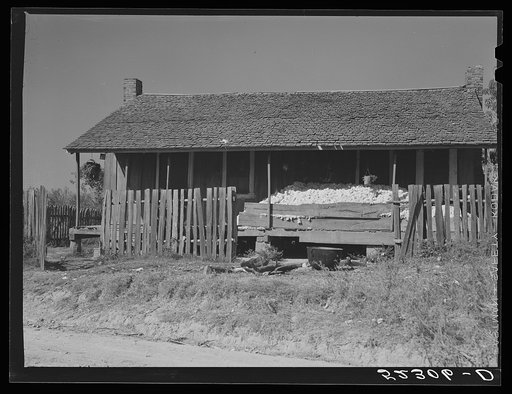 Cotton on front porch of tenant's home being stored until they get a bale to take to the gin. Mississippi