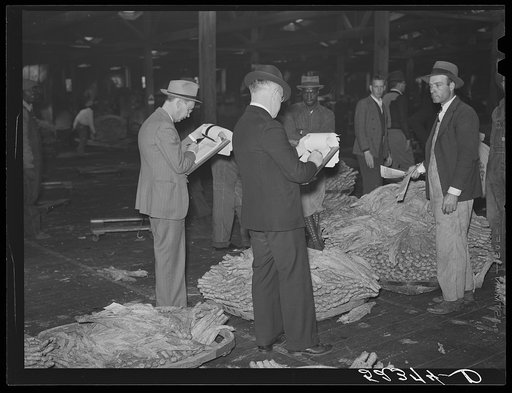 Bookmen for the warehouse follow the sale and check the prices of tobacco after the auction. Durham, North Carolina