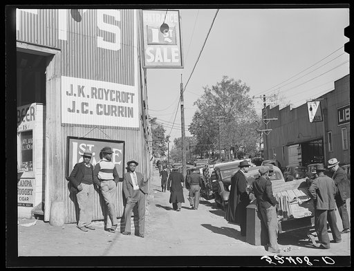 Untitled photo, possibly related to: Many stories are exchanged by buyers and farmers while waiting around outside warehouse during auction sales. Durham, North Carolina
