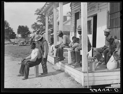 Untitled photo, possibly related to: Negroes cut each other's hair in front of plantation store after being paid off on Saturday. Mileston Plantation, Mississippi Delta