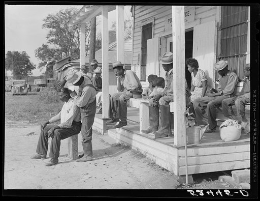Untitled photo, possibly related to: Negroes cut each other's hair in front of plantation store after being paid off on Saturday. Mileston Plantation, Mississippi Delta