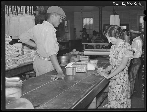 Negro wagehand purchasing groceries after being paid off on Saturday in plantation store. Mileston Plantation, Mississippi Delta