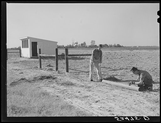 Farmer and son building fence around their field. Sunflower Plantation, Merigold, Mississippi Delta