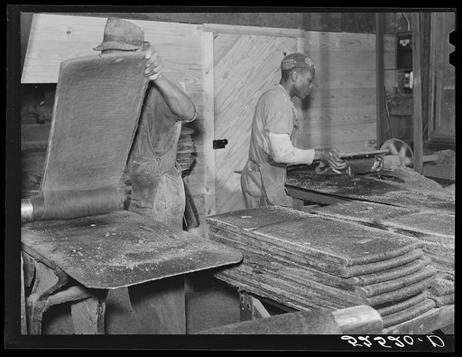 Untitled photo, possibly related to: Removing chinese hair mat from cake of cottonseed meal. This meal is fed to cattle. Clarksdale, Mississippi Delta