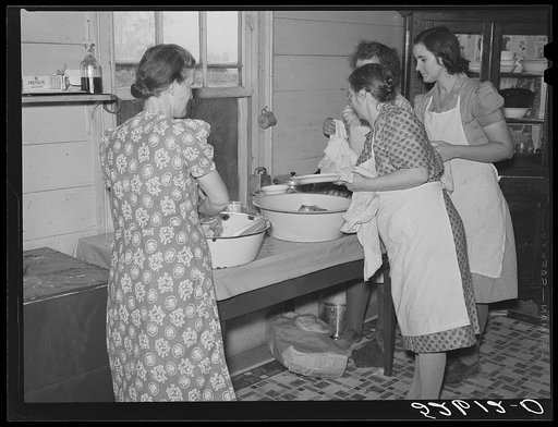 Mrs. Fred Wilkins and other women of the Wilkins clan washing dishes in her kitchen after large dinner for the men who were shucking corn. Tallyho, Stem, North Carolina. Granville County, See subregional notes. (Odum) November 16, 1939