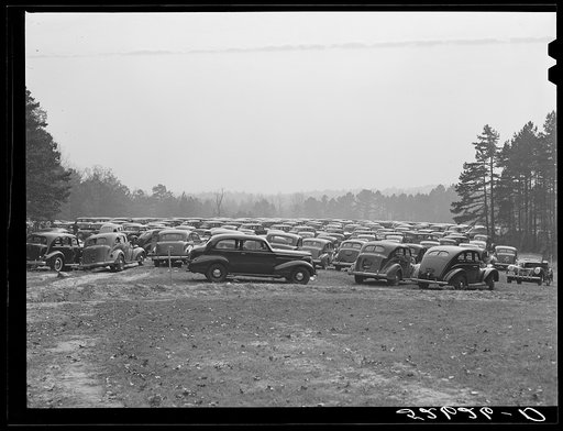 Cars parked in field near Duke University Stadium on day of Duke-Carolina football game. Durham County, North Carolina