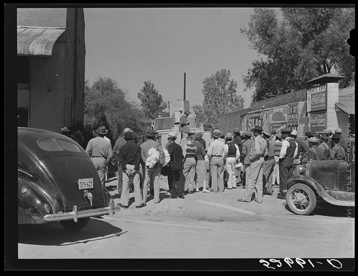 Itinerant vendor selling pieces of material and so forth from trucks in vacant lot on Saturday. Belzoni, Mississippi Delta