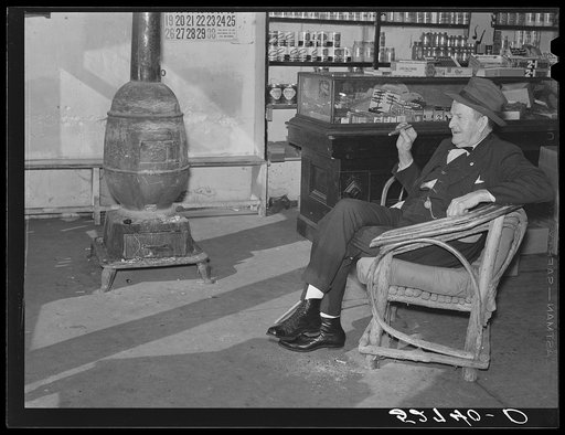 Mr. R.B. Whitley visiting in his general store. He is president of the bank and practically owns and runs the town. He is a big landowner, owns Whitley-Davis Farm and a cotton mill in Clayton. He said he cut down the trees and pulled up the stumps in that town of Wendell. Wake County, North Carolina