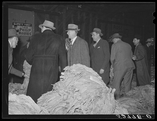 Untitled photo, possibly related to: Farmers listening to sales talk of patent medicine vendor in warehouse during tobacco auctions. Durham, North Carolina